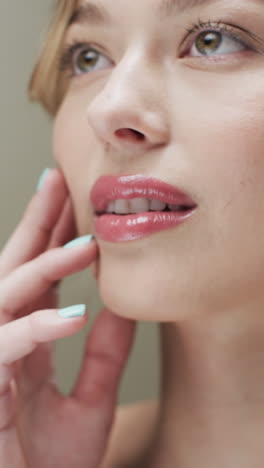Vertical video of caucasian woman with blond hair touching face, copy space, slow motion