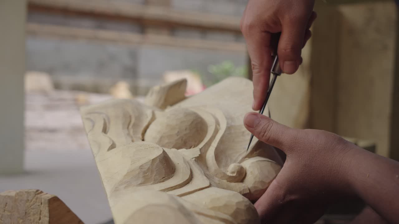 칼로 나무로 만든 인도네시아 바롱 마스크를 형성하는 사람