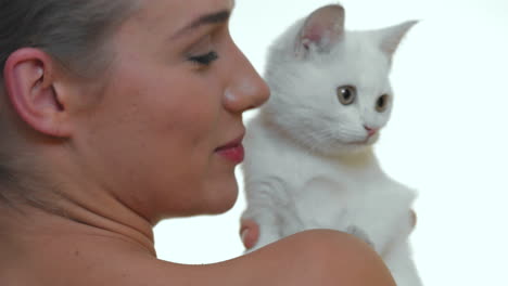 linda mujer rubia posando con gato blanco