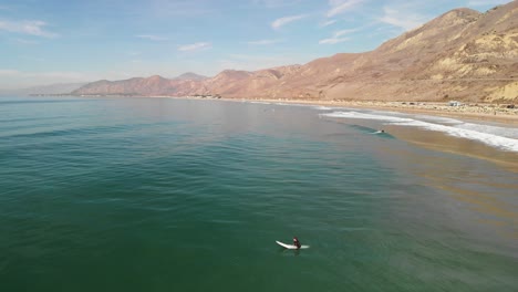 Aerial-shot-of-surfers-waiting-to-catch-a-wave-in-southern-California