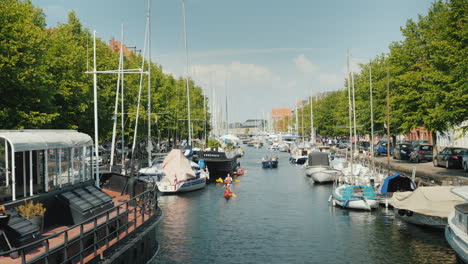people kayak through the canals of copenhagen