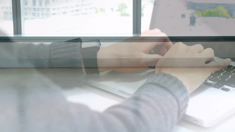 Animation-of-hands-using-laptop-over-male-and-female-colleague-walking-in-modern-building