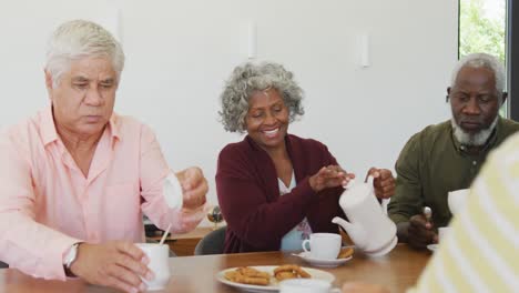 Happy-senior-diverse-people-drinking-tea-at-retirement-home