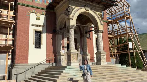 tourist woman walking by sinaia monastery in romania. dolly out