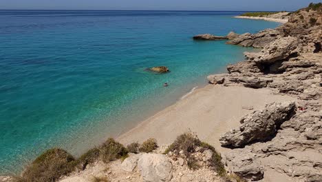 Wunderschöne-Bucht-Mit-Ruhigen-Stränden,-Umgeben-Von-Klippen,-Die-Von-Türkisfarbenem-Meerwasser-Umspült-Werden,-Sommerurlaub-In-Albanien