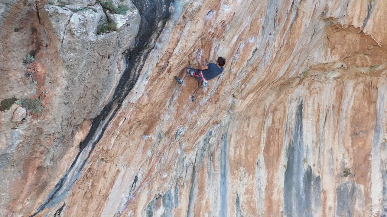 Mountain climber is climbing overhang mountain wall