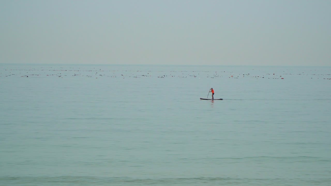 turista de pie en las pequeñas filas de botes en la playa de seongjong en busan, corea del sur