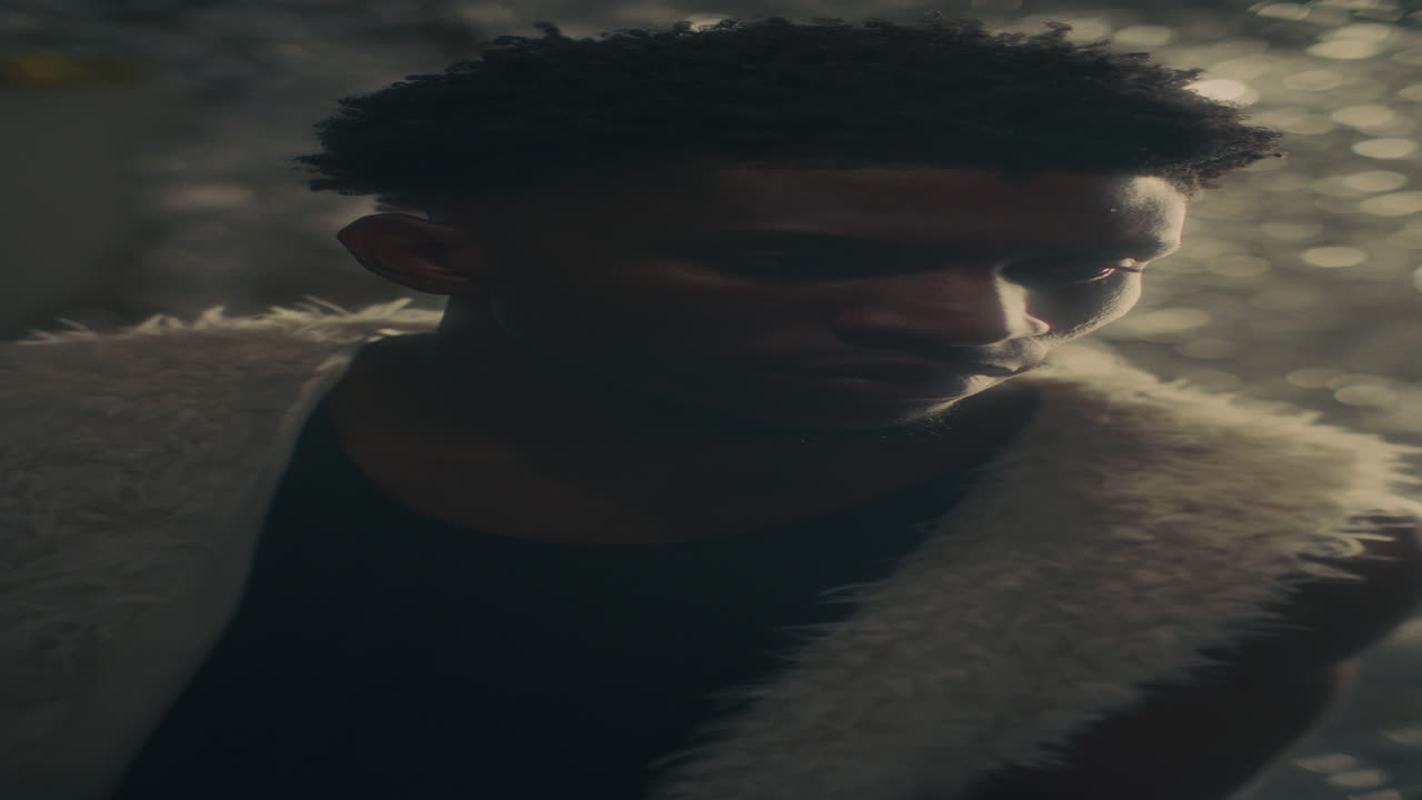 Contemplative Black Man Looking Downward under Fading Light