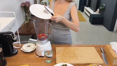 mujer preparando un batido en la cocina