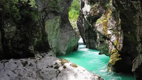 vista estática del agua turquesa del río soca que fluye a través del estrecho desfiladero entre enormes montañas rocosas