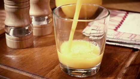 orange juice pouring into a glass, the morning breakfast. slow motion with rotation tracking shot.