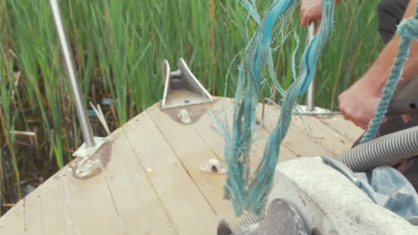 reffing hook being used to remove old caulking on foredeck