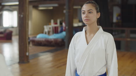 medium shot of female fighters bowing before karate training