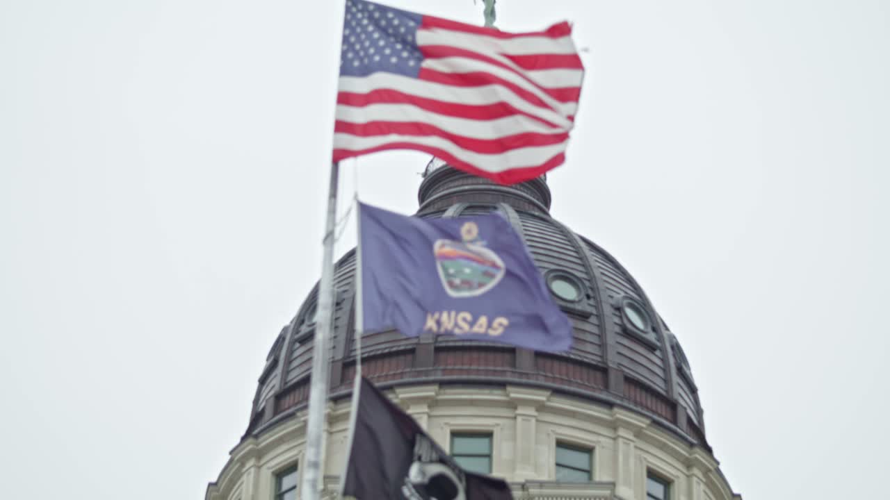 banderas ondeando en cámara lenta en el edificio del capitolio del estado de kansas en topeka, kansas con video de primer plano
