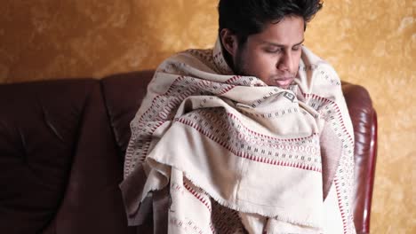 man wrapped in a blanket on a couch