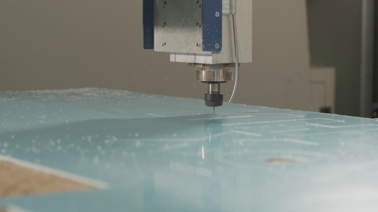 máquina de corte cnc en el trabajo, corte de hojas de plástico acrílico. producción de carteles publicitarios