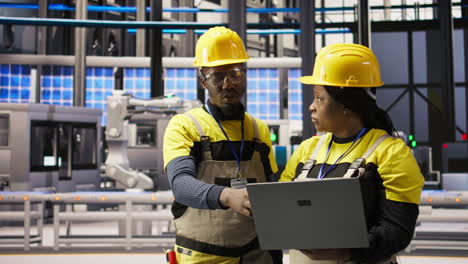 vertical video smart factory engineering team using laptop to calibrate high tech machinery