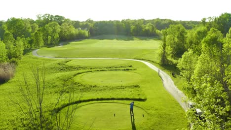 Video-Aéreo-De-Un-Hermoso-Campo-De-Golf-Con-Un-Golfista-Golpeando-Una-Pelota-Con-Un-Conductor-Desde-El-Tee-De-Salida