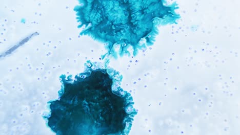 dos tonos de tinta azul dispersados en el agua con una apariencia nublada y burbujas flotantes