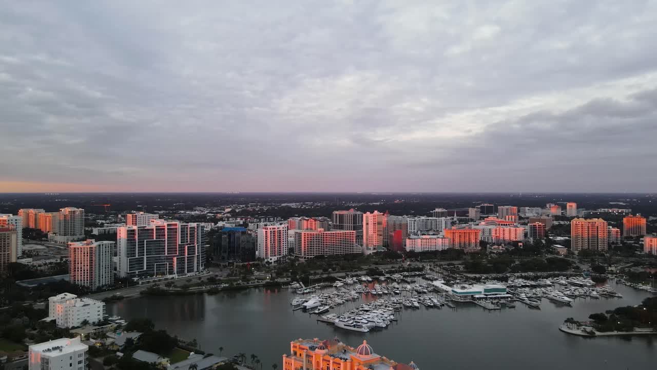 Skyline drone footage of beautiful Sarasota, Florida during sunset. This footage captures the bay area of Sarasota and shows Golden Gate Point and the Marina. 60 fps.
