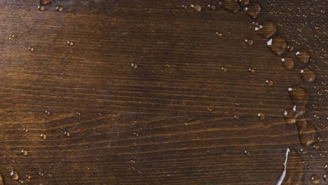 raindrops on a wooden board. the wind blows off drops of water.