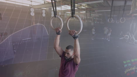 animación de datos de procesamiento de gráficos sobre hombre biracial entrenamiento cruzado en anillos de gimnasio en gimnasio