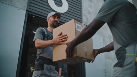 delivery workers handle packages at a warehouse loading dock