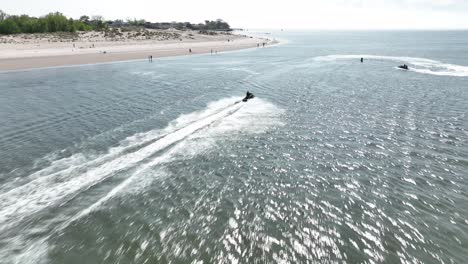 An-aerial-view-over-Gravesend-Bay-in-Brooklyn,-NY-as-two-jet-ski-riders-enjoys-the-sunny-day