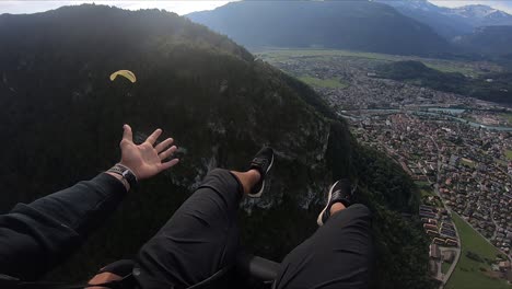 pov shot of a young man stretching his arm and hand out in joy, happiness and excitement over the ride in the air over interlaken village in switzerland