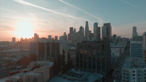 Cinematic-view-of-Downtown-Los-Angeles-with-amazing-sunset-glow,-drone-rising-over-buildings