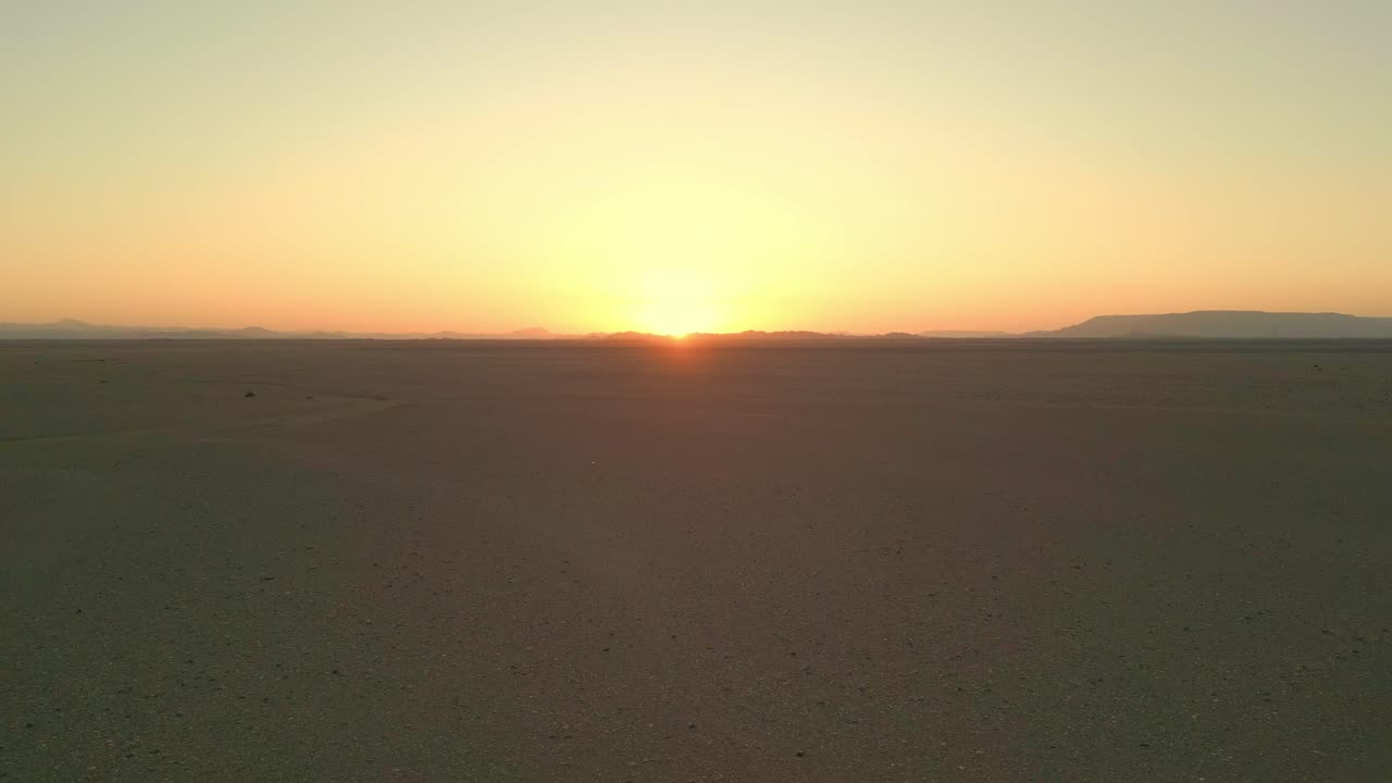 vista aérea de drones de la serena puesta de sol del desierto sobre un vasto horizonte, capturando la tranquila belleza del paisaje desértico al anochecer en arabia saudita
