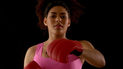 fit woman in pink wearing boxing gloves