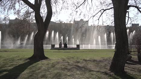 personas relajándose junto a una fuente en un parque de la ciudad