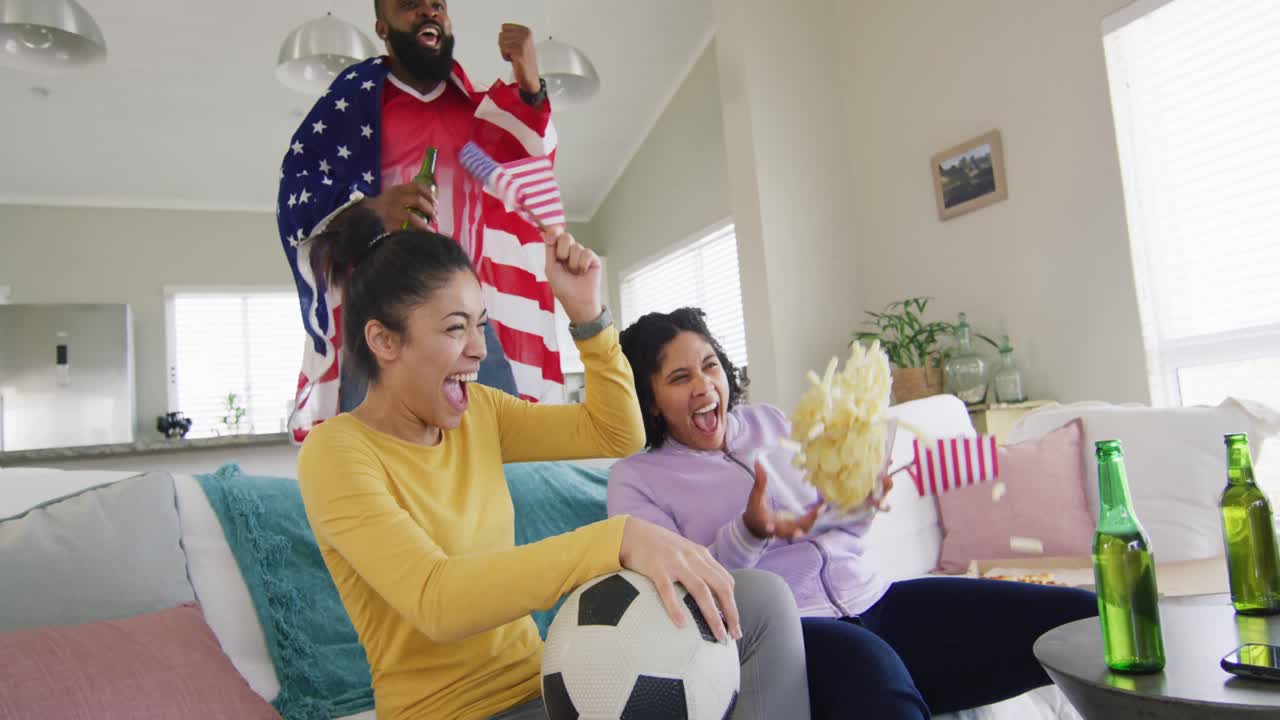 amigas y amigos diversos viendo la televisión celebrando la victoria estadounidense en cámara lenta.