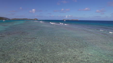 volando por encima de los arrecifes de coral y las aguas poco profundas del mar del caribe por la costa de las islas vírgenes británicas, toma de dron