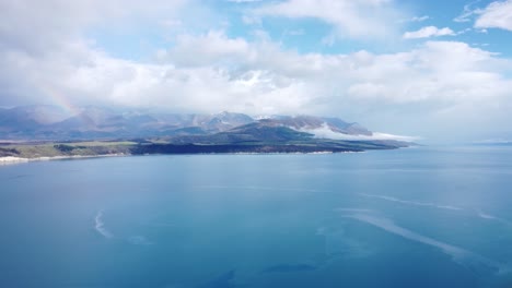 drone view of blue lake pukaki and mountains on a sunny summer day in new zealand.