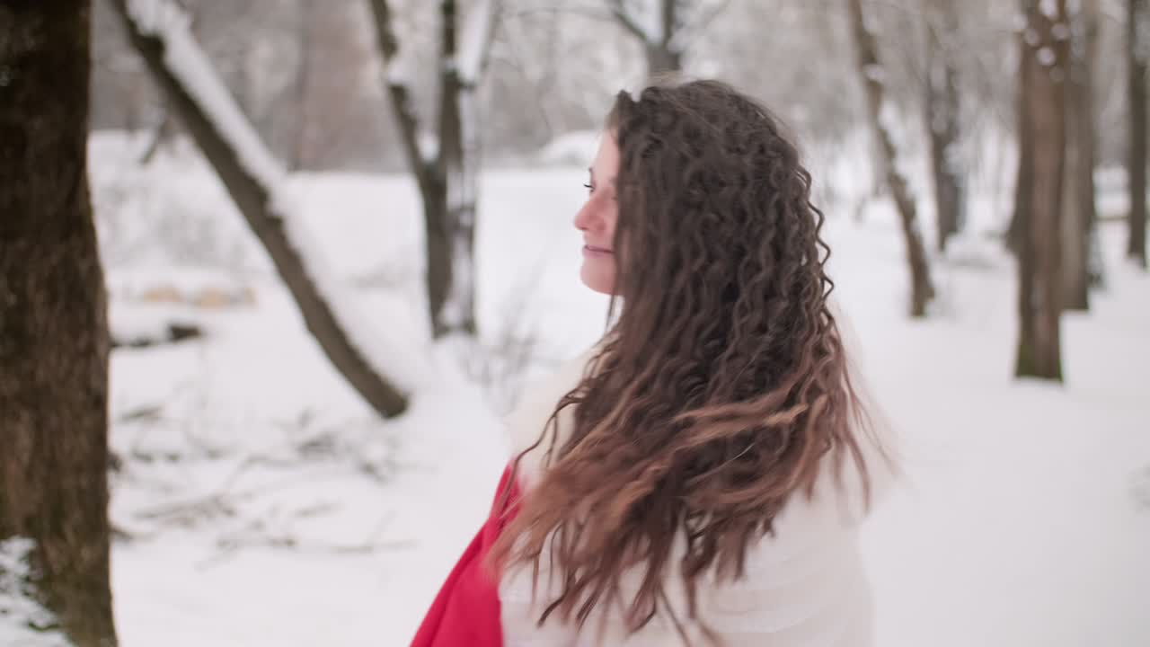 la mujer disfruta de la naturaleza y se divierte al aire libre. mujer joven girando en el parque de invierno