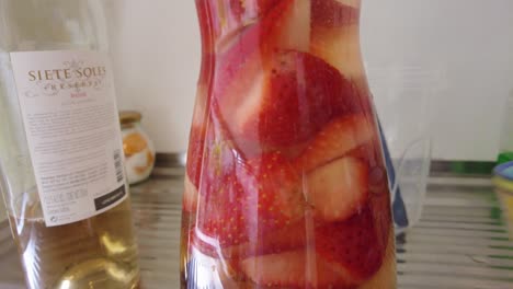 las fresas y las manzanas se presentan bellamente en un frasco moderno, creando una exhibición visualmente atractiva