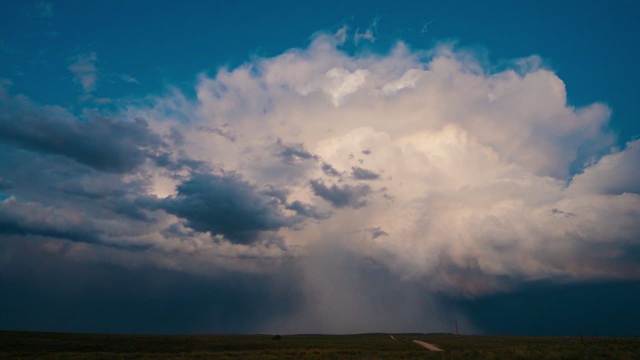 Dramatic Storm Clouds with Rain Shaft Over a Rural Landscape