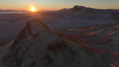 rising sun being occluded by foreground mountain in mountainous moorland winter landslip landscape at dawn