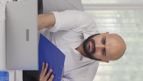vídeo vertical de un trabajador de oficina en casa tomando notas, anotando información.