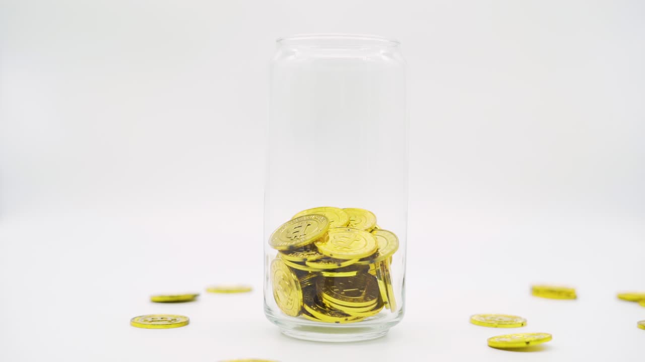 Close up Bitcoin gold coins falling in to jar. Crypto currency coin.