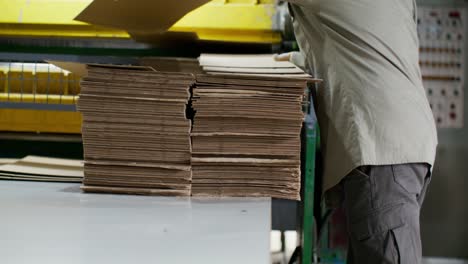 factory worker handling cardboard boxes and materials