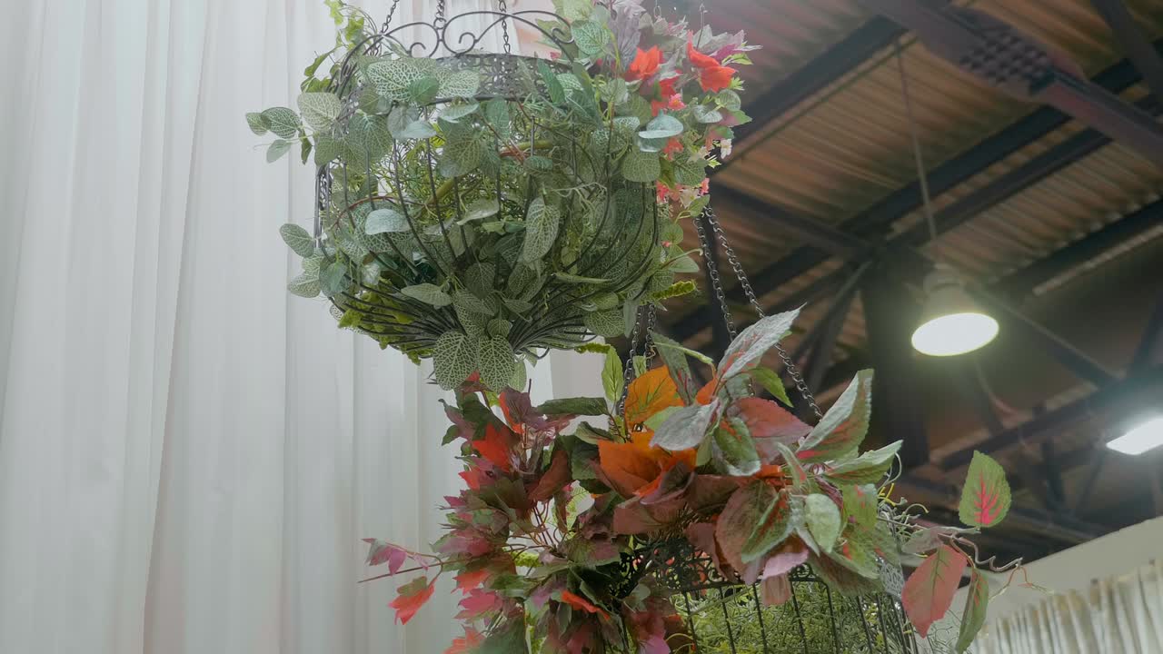 un hermoso arreglo de flores en el volumen de alambre cuelga alto