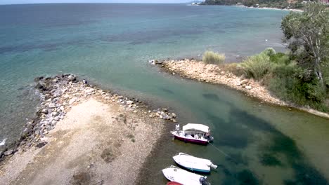 Vista-Aérea-Del-Pequeño-Puerto-Natural-En-El-área-De-Agia-Paraskevi-Halkidiki,-Grecia,-Avance-Por-Drones