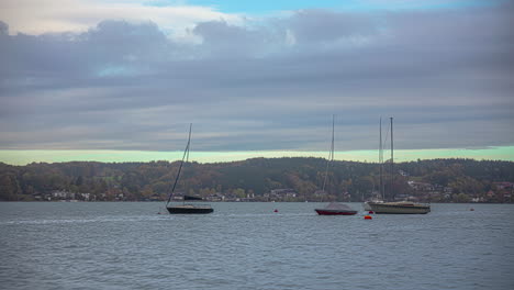 beautiful timelapse of four boats anchored in lake attersee at sunset