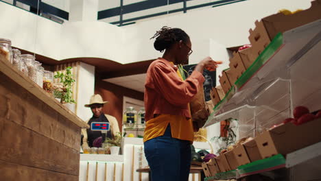 regular client putting bio homegrown vegetables in a paper bag