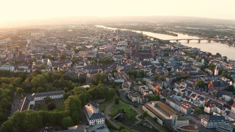 approaching the city of mainz in germany with a drone on a sunny summer evening with the rhine river bridge in the background