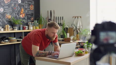 food blogger using laptop while working on content in kitchen