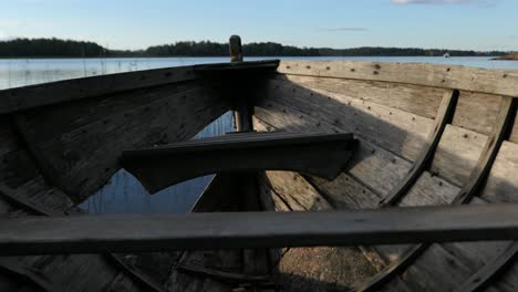 old rustic abandoned wooden boat by calm water sea, close up